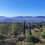 Panoramic landscape of Athens city skyline with surrounding hills.