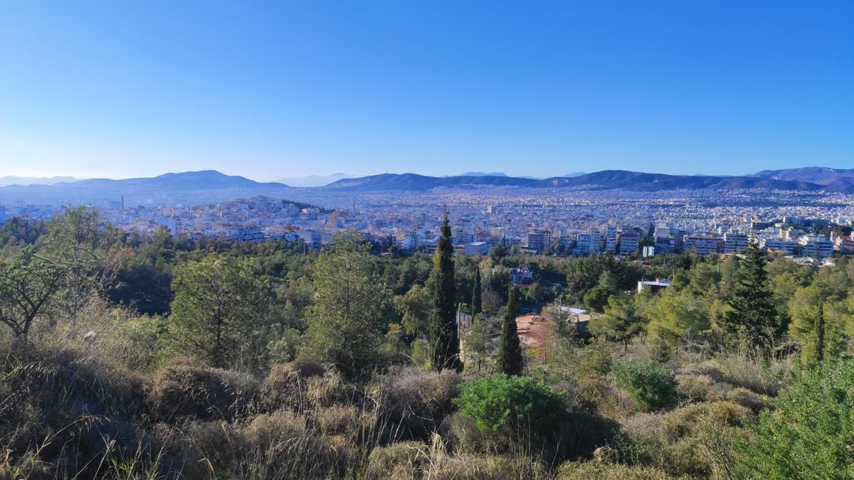 Panoramic landscape of Athens city skyline with surrounding hills.